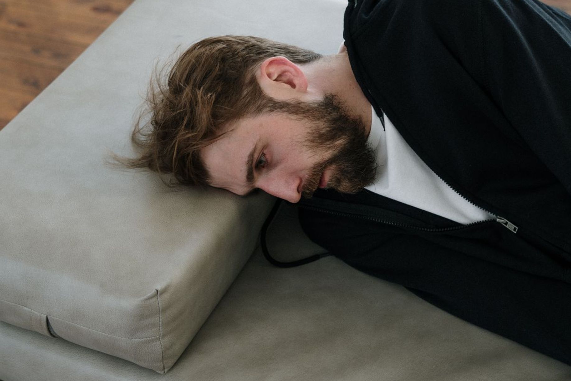 muž ležící na gauči v depresi